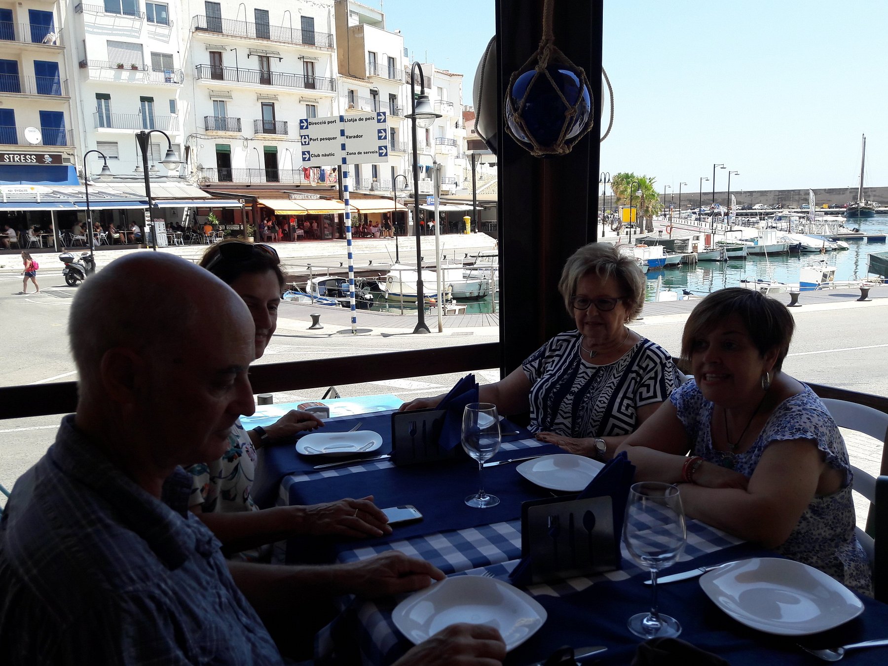 Clientes comiendo junto a la ventana con vistas al puerto